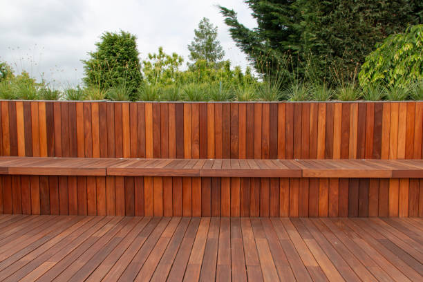 istock Wood fence cladding and decking, garden greenery on the background 1977356949