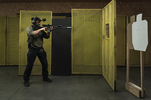 A man engages cqb tactical rifle shooting at a shooting range. High quality photo