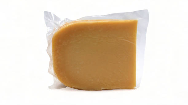 istock One parmesan cheese triangle in a transparent plastic wrap with soft shadows stands on a white background. Vacuum plastic bag with cheese. Mockup, packaging template with clipping path. 1977381567