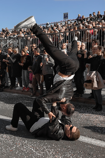 Menton, France-February 12, 2023: street performer doing a handstand on another person's hand in front of an audience