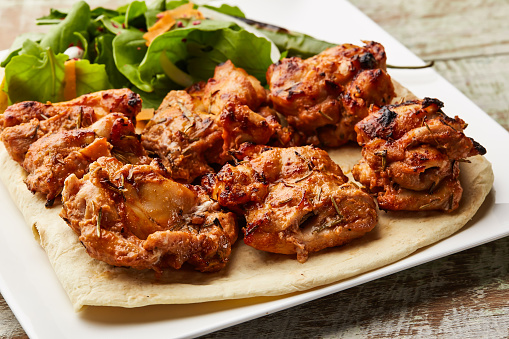 Tandoori chicken tikka with salad served in dish isolated on table top view of arabic food