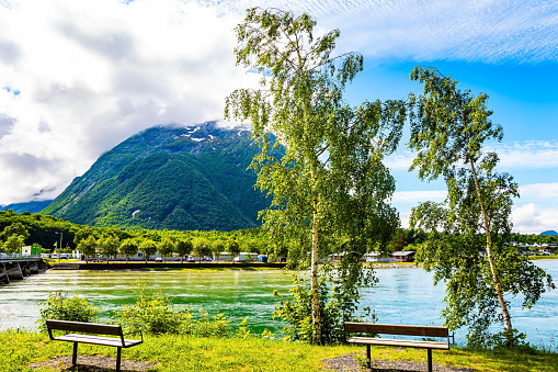 Gorgeous sunny weather in Norway. The huge lake is surrounded by picturesque rounded hills. There are benches on the lake embankment. Travel to fabulous Scandinavia