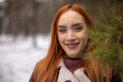 Portrait of woman in nature, she's looking at camera