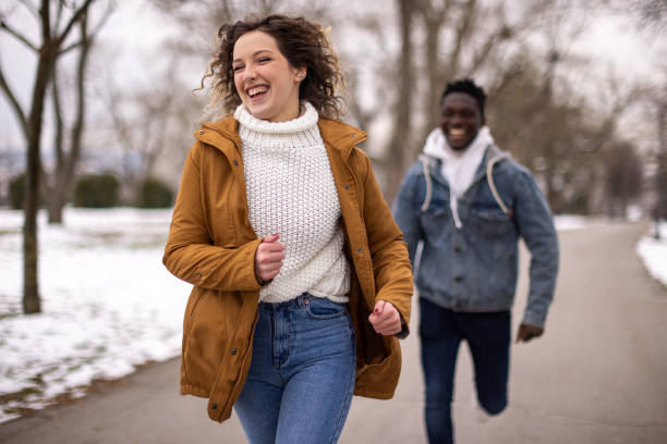 istock Young couple having fun on cold day at public park during day 1977417559