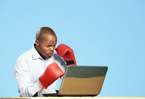 Man's conflict with his laptop takes a serious turn as he spars with it in boxing gloves.