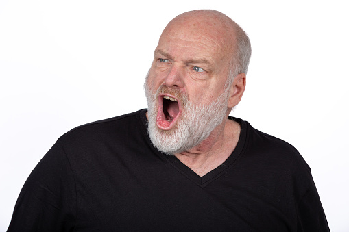 Intense Middle Age Bearded Man Shouting with Anger in Black T-Shirt, Expressive Facial Emotion on White Background - Powerful Emotional Portrait