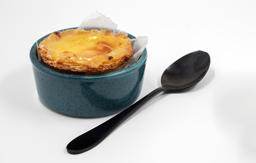 Plate with one Portuguese Pastel de Nata quiche. Pastel de Belem is a monastic and cult pastry in the form of cups with a burnt top and a crispy puff pastry crust. Sweet dessert with egg cream