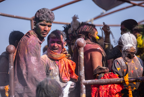 Varanasi, Uttar Pradesh, India - March 2023: Masan holi, Group of unidentified people celebrating the festival of holi at manikarnika ghat with colors and fun. Manikarnika ghat is a cremation point.