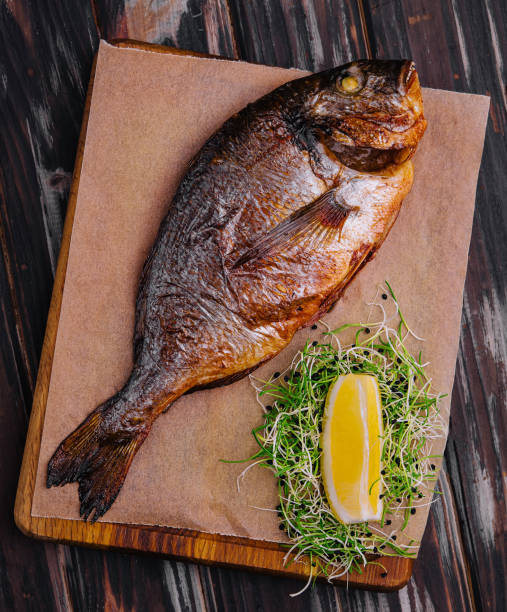 istock Board with fried dorado on wooden background 1977469351