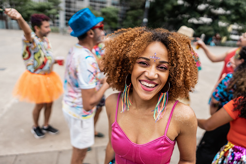 Portrait of a young woman having fun at a street carnival party