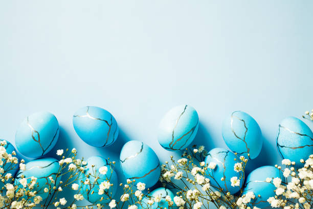 istock Happy Easter greeting card. Flat lay composition with elegant Easter eggs with flowers on blue background. 1977478094