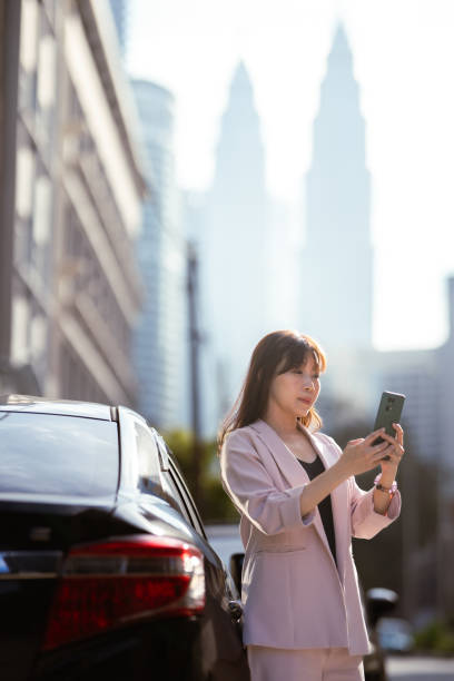 istock On-the-Go Glamour: When Fashion and Tech Unite by the Car Side 1977484933