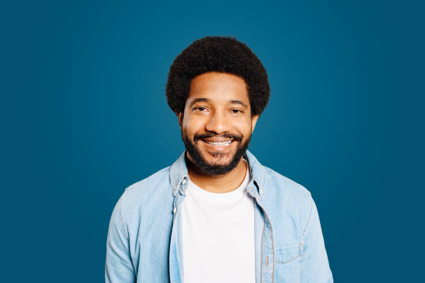 istock Cheerful Brazil man stands with a confident smile against a rich blue backdrop 1977506249