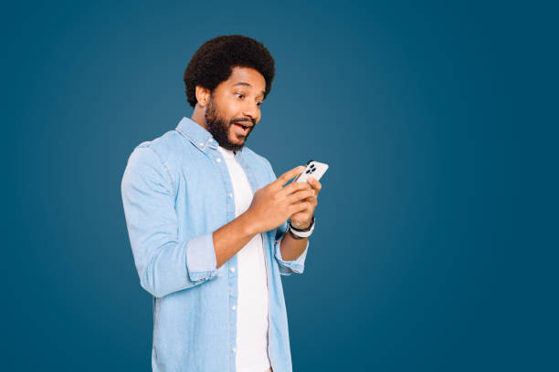 istock Surprised Latin man looks to smartphone screen with a playful, intrigued expression while using his phone 1977507307