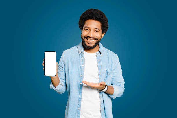 istock Handsome young Brazilian man shows an empty smartphone screen with an inviting smile 1977507823