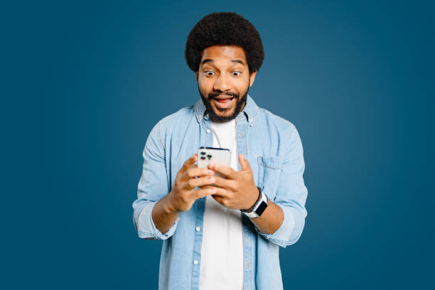 istock Young man looks surprised and excited using a smartphone, embodying a spontaneous moment 1977507839