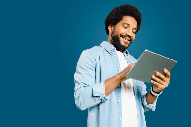istock Smiling while using his tablet, the young Latin man presents a scenario where technology meets daily life 1977508328