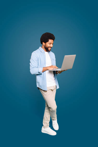 istock A young Brazilian man, male freelancer or student, standing and using a laptop 1977508385