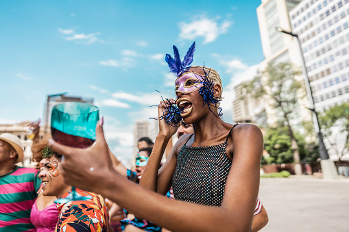 Young woman talking on mobile phone during a street carnival party