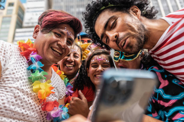 istock Friends using mobile phone on a street carnival party 1977520004