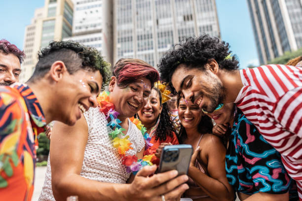 istock Friends using mobile phone on a street carnival party 1977520011
