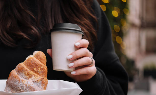 istock girl holding croissants and coffee 1977523314