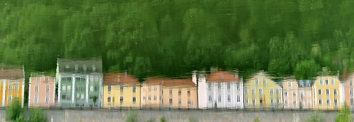 Panoramic view of reflected house in river. colorful row of houses at river Danube, Passau, Bavaria, Germany. Dreamy view of houses and trees on river.