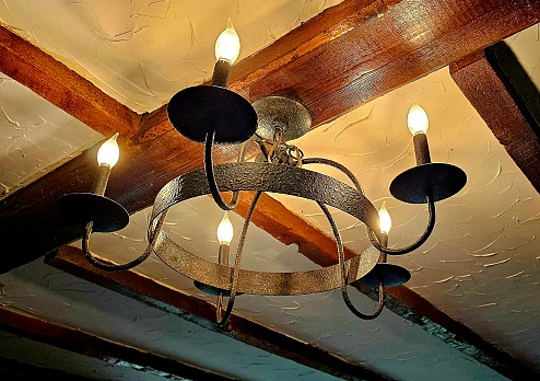 Cast iron electric chandelier with farmhouse ceiling