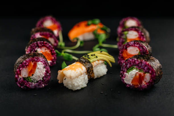 istock Aesthetic composition with sushi rolls on a dark background. Ready advertising banner. Healthy eating concept, seafood, salmon, shrimp, ready food. 1977531059