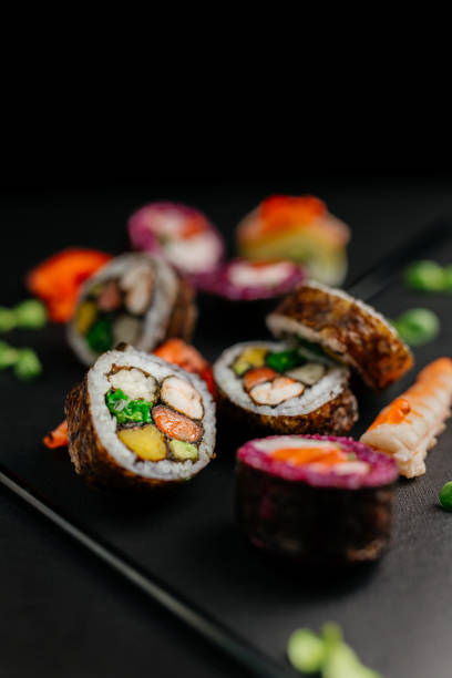 istock Aesthetic composition with sushi rolls on a dark background. Ready advertising banner. Healthy eating concept, seafood, salmon, shrimp, ready food. 1977532172