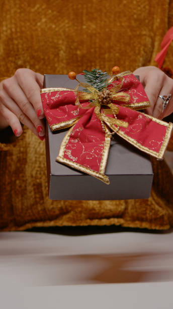 istock Close up of hands holding present box with ribbon and bow tie 1977554376