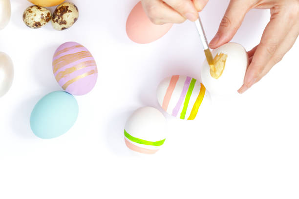 istock Woman painting Easter eggs on white background. Easter day. 1977587300