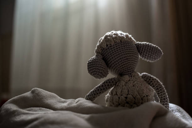 Studio shot of a plush hedgehog toy carrying ear muffs isolated on gray background