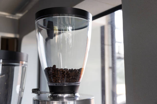 istock grinder coffee machine. Coffee beans inside the machine hopper of coffee shop 1977597515