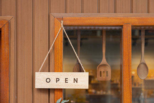 open sign board hang on the front of the bakery shop.