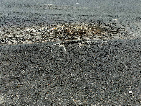 Pits and cracks on the asphalt of the road