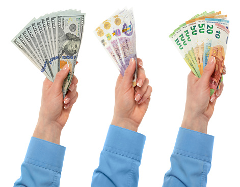 Female hand holding euro, dollars and British currency isolated on white background with clipping path. Close up