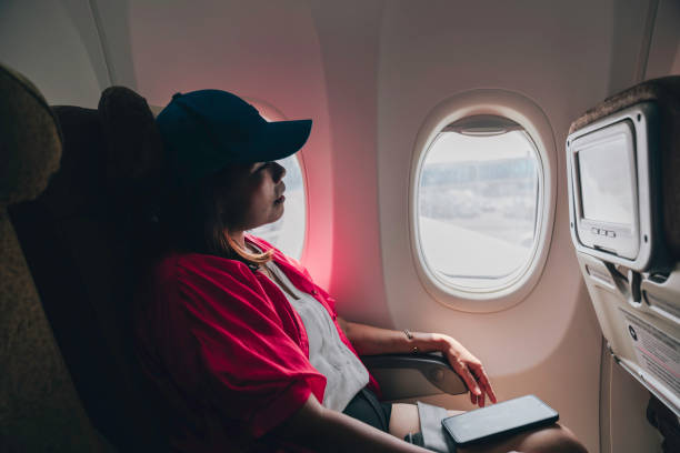 istock Asian woman looking through window on a plane 1977600783
