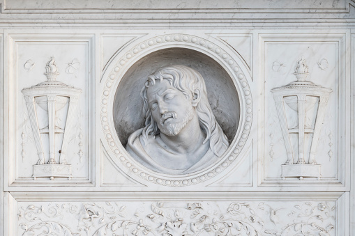 Marble head of young woman, ancient Greek goddess bust i on grey background with copy space .