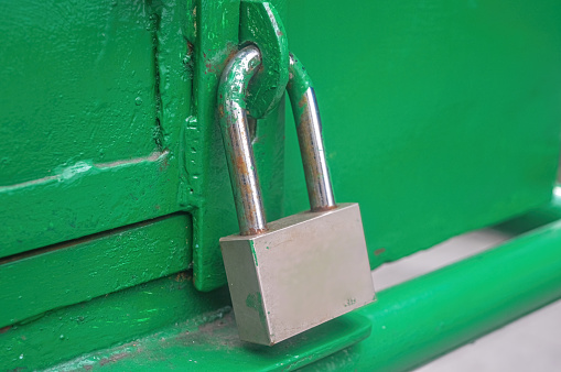 an iron padlock that locks the green iron door