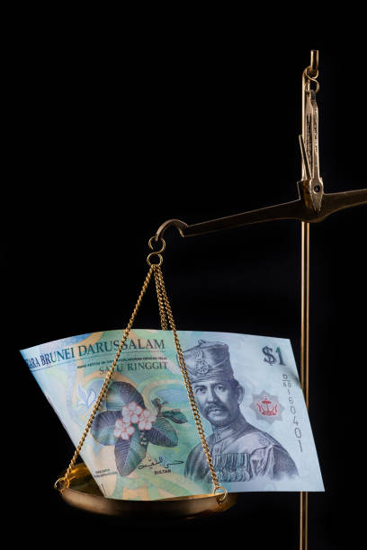 istock Brunei 1 dollar bill on a gold scale 1977632791