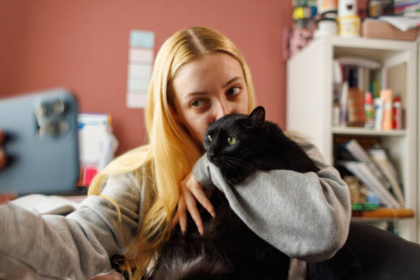 istock Young Woman Taking Selfie With Cat 1977662894