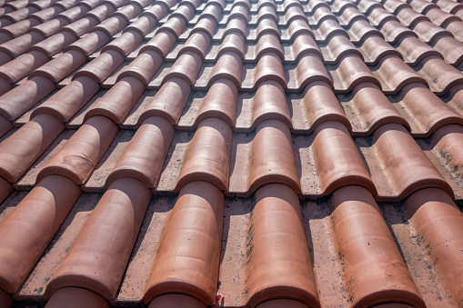 Roof tiles background texture. Brown corrugated roof tile element, traditional Greek house roofing in sunlight. Waterproof protective clay. Copy space