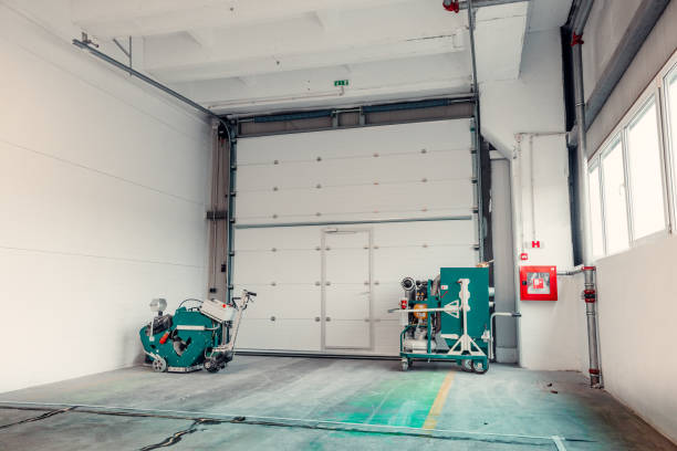 istock two concrete or floor grinding machine, polishing machine by an automatic door inside a industrial space 1977703317