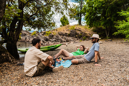 Friends talking during a picnic at island beach in a Patagonia, Argentina