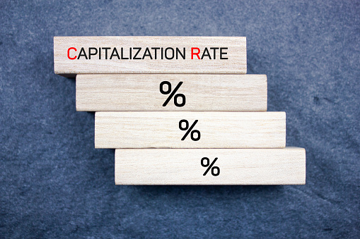 CAPITALIZATION RATE text, acronym on wooden blocks. Capitalization rate financial concept.