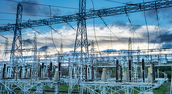 Sunset behind substation towers with blue sky Photo. download image