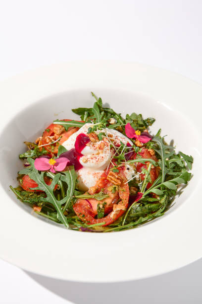 istock Italian salad with burrata, tomatoes, and arugula, elegantly arranged and garnished with edible flowers 1977794190