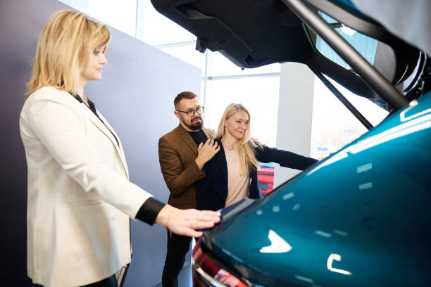 istock Two people inspecting the trunk of a blue car 1977800693