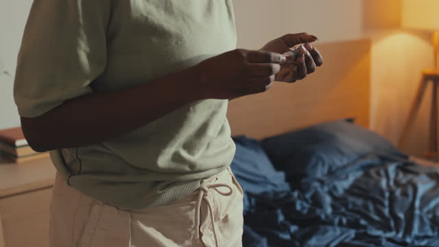 Black Woman Injecting Insulin in Abdomen in Bedroom